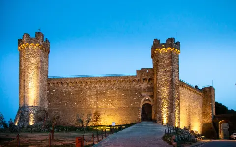 La Fortezza di Montalcino, illuminata di sera, è un luogo imperdibile da vedere.