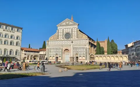 Piazza Santa Maria Novella a Firenze, con la facciata rinascimentale della basilique santa maria novella in primo piano e il Grand Hotel Minerva sulla sinistra.