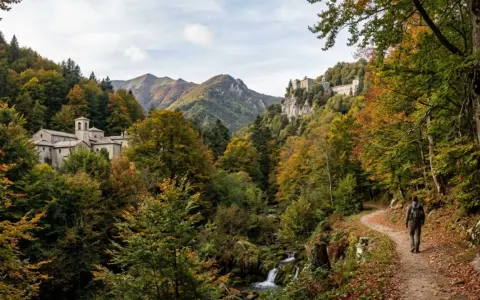 Sentiero nel Parco Nazionale delle Foreste Casentinesi Monte Falterona e Campigna, con un escursionista che cammina tra boschi autunnali e antichi edifici storici.
