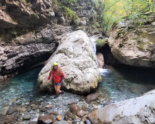 Esploratrice sorridente nel canyon dell'Orrido di Botri, tra rocce imponenti e acque cristalline.