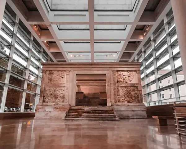 L'Ara Pacis, un capolavoro di scultura romana, risplende sotto la luce moderna di un museo.