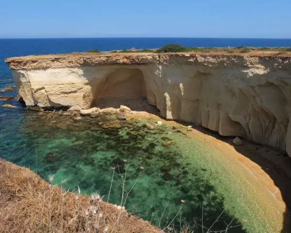 La spiaggia della Pillirina, con le sue acque cristalline e le suggestive grotte scavate nella roccia calcarea, offre uno scenario naturale mozzafiato.