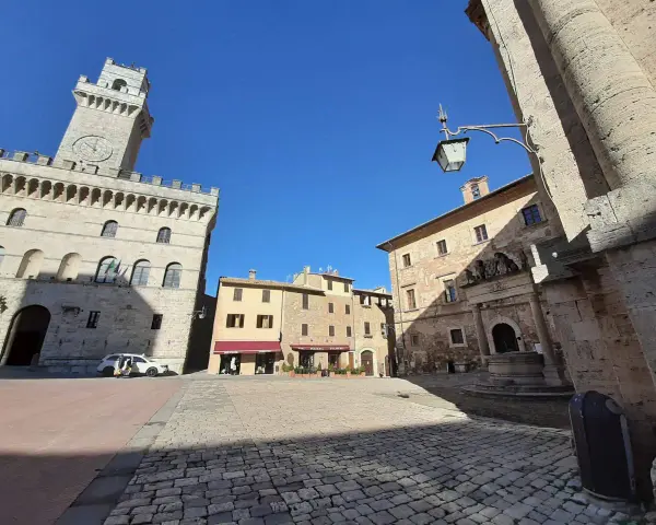 La piazza grande di Montepulciano, con il suo imponente palazzo comunale e la torre dell'orologio, invita a una passeggiata tra botteghe e caffè.