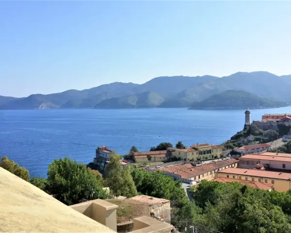 Panoramica di Portoferraio centro storico cosa vedere: fortezze, mare blu e colline verdi.