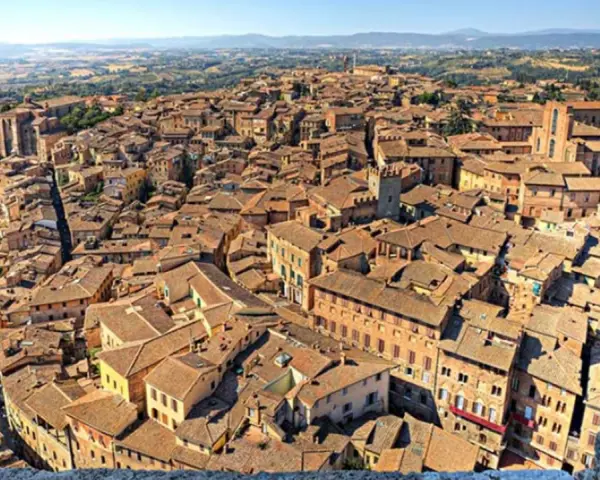 Vista dall'alto di Siena, con la Torre del Mangia che domina il panorama, evocando la sua leggenda.