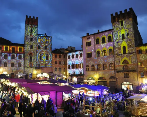 Mercatino natalizio ad Arezzo, con palazzi illuminati da proiezioni colorate. Vale la pena visitare Arezzo per questa magica atmosfera.