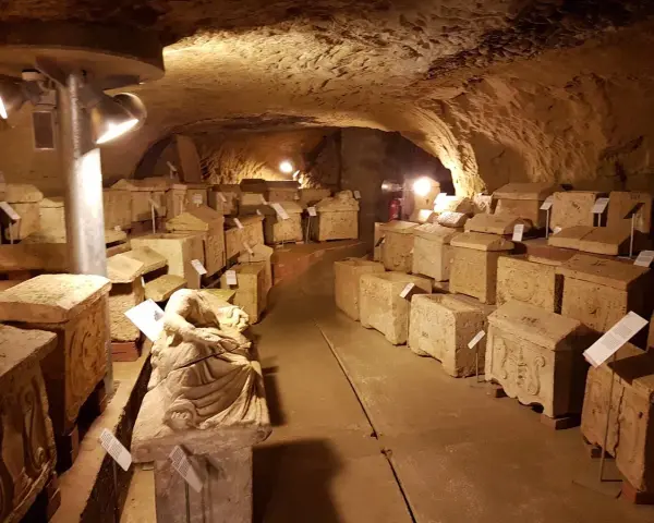 Antiche urne e sarcofagi etruschi, testimoni silenziosi del passato, esposti nel suggestivo ipogeo del Duomo di Chiusi.