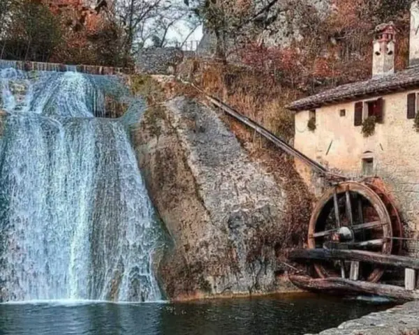 Cascata e antico molinetto della Croda, con la ruota in legno che gira grazie all'acqua.