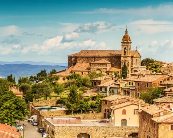 Panoramica di Montalcino con la sua imponente cattedrale e le colline toscane. Un luogo incantevole da scoprire, tra le cose da vedere a Montalcino e dintorni.