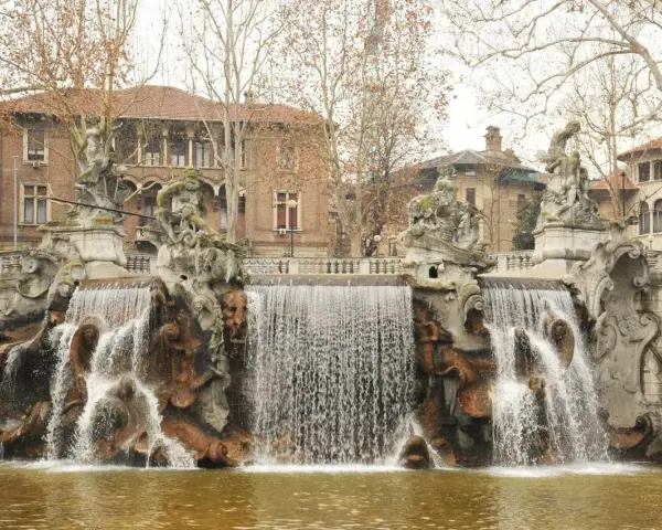Fontana monumentale nel Parco del Valentino, con statue e cascate d'acqua che scendono su rocce scultoree.