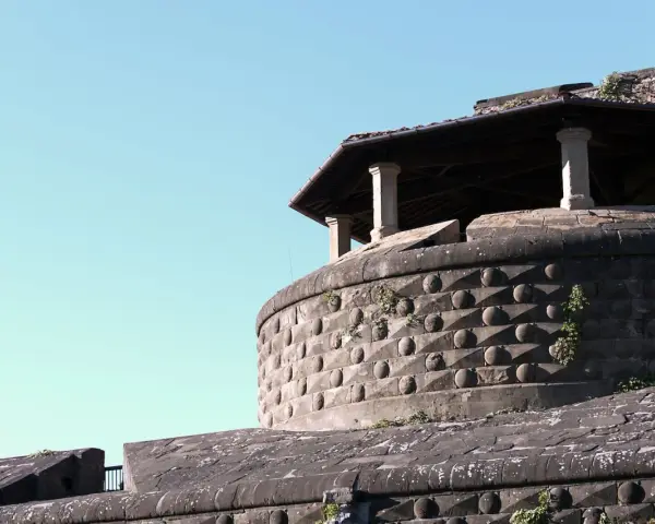 La fortezza da basso, con la sua muratura bugnata e il tetto spiovente sorretto da colonne, si staglia contro il cielo azzurro.