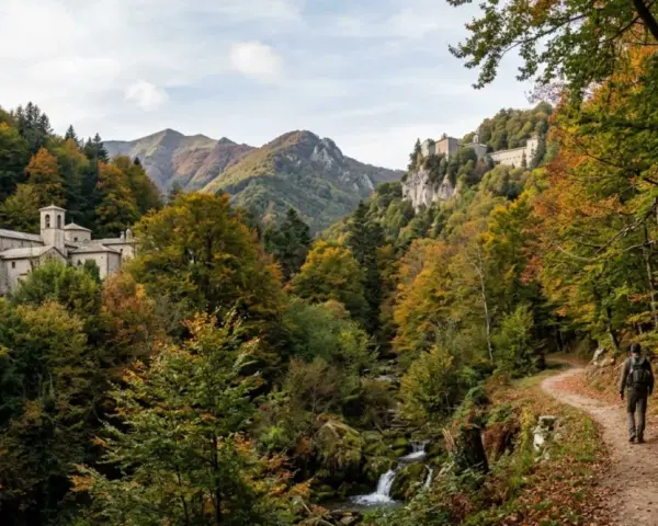 Sentiero nel Parco Nazionale delle Foreste Casentinesi Monte Falterona e Campigna, con un escursionista che cammina tra boschi autunnali e antichi edifici storici.
