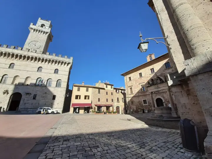 La piazza grande di Montepulciano, con il suo imponente palazzo comunale e la torre dell'orologio, invita a una passeggiata tra botteghe e caffè.
