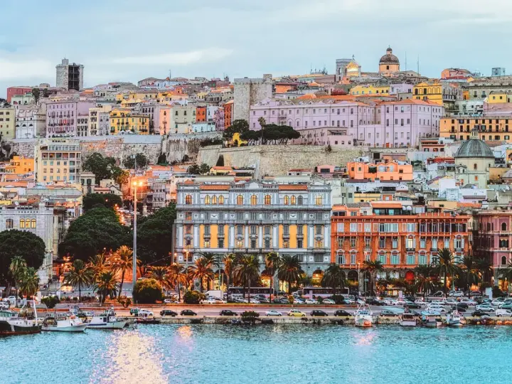 Vista del porto di Cagliari con edifici colorati e palme. Perfetto per scoprire cosa fare a Cagliari.