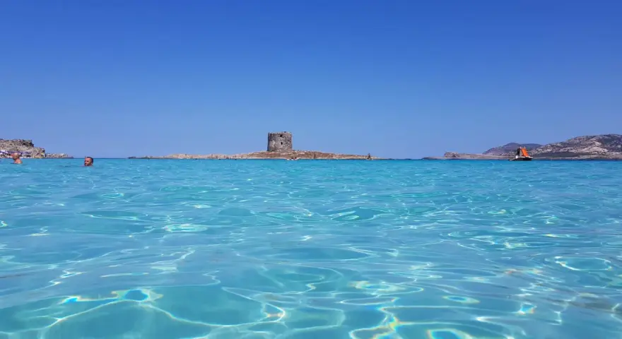 Acque cristalline e un'antica torre su un isolotto: ecco la spiaggia più bella d'Italia, un paradiso azzurro.