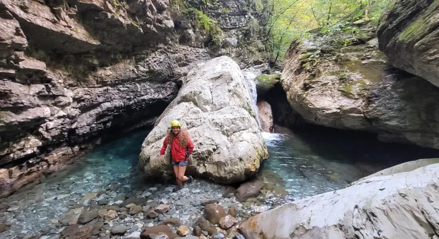 Esploratrice sorridente nel canyon dell'Orrido di Botri, tra rocce imponenti e acque cristalline.