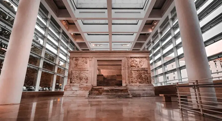 L'Ara Pacis, un capolavoro di scultura romana, risplende sotto la luce moderna di un museo.