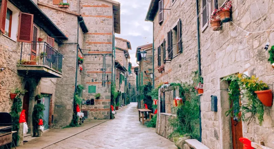 Un vicolo suggestivo ad Abbadia San Salvatore, con case in pietra e decorazioni natalizie. Scopri cosa vedere in questo borgo incantevole.