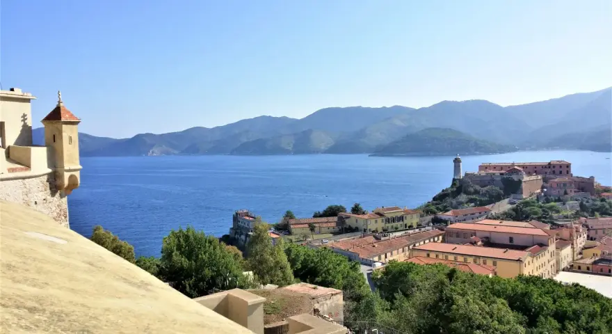 Panoramica di Portoferraio centro storico cosa vedere: fortezze, mare blu e colline verdi.