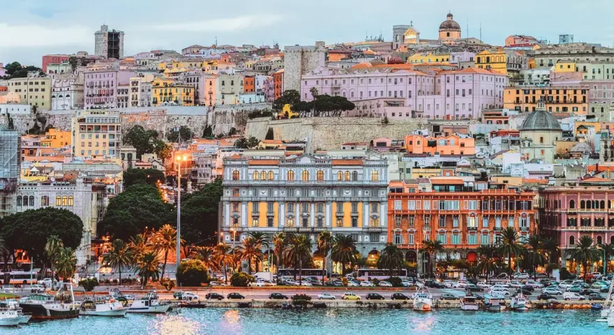 Vista del porto di Cagliari con edifici colorati e palme. Perfetto per scoprire cosa fare a Cagliari.