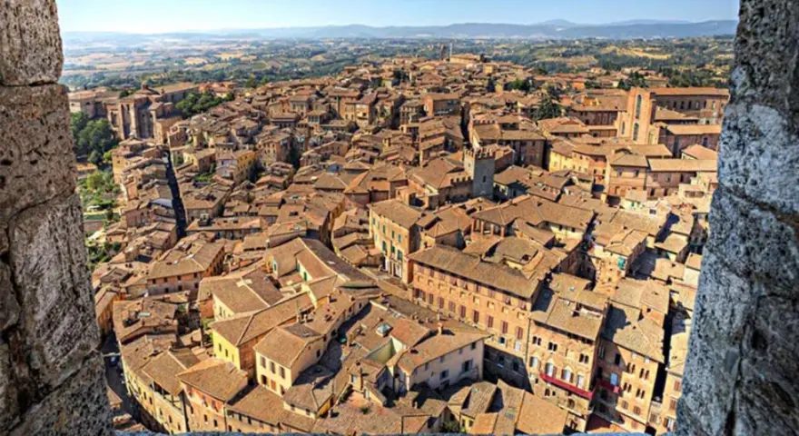 Vista dall'alto di Siena, con la Torre del Mangia che domina il panorama, evocando la sua leggenda.