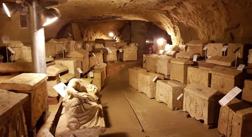 Antiche urne e sarcofagi etruschi, testimoni silenziosi del passato, esposti nel suggestivo ipogeo del Duomo di Chiusi.