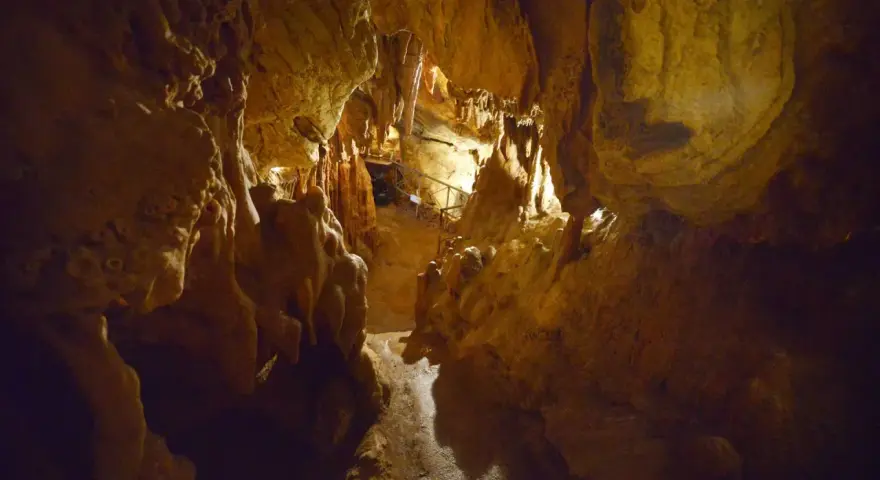 Interno della grotta Maona a Montecatini, con stalattiti e stalagmiti illuminate.