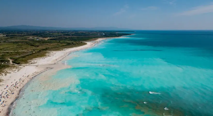 Le spiagge bianche di Rosignano, con acque turchesi cristalline e bagnanti che si godono il sole.