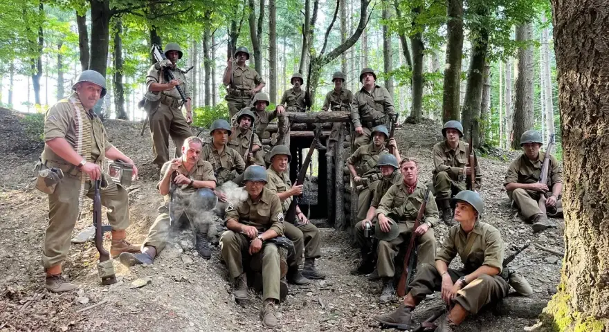 Soldati in uniforme militare, armati e pronti, si riposano in un bosco, forse durante una sosta al passo del giogo.