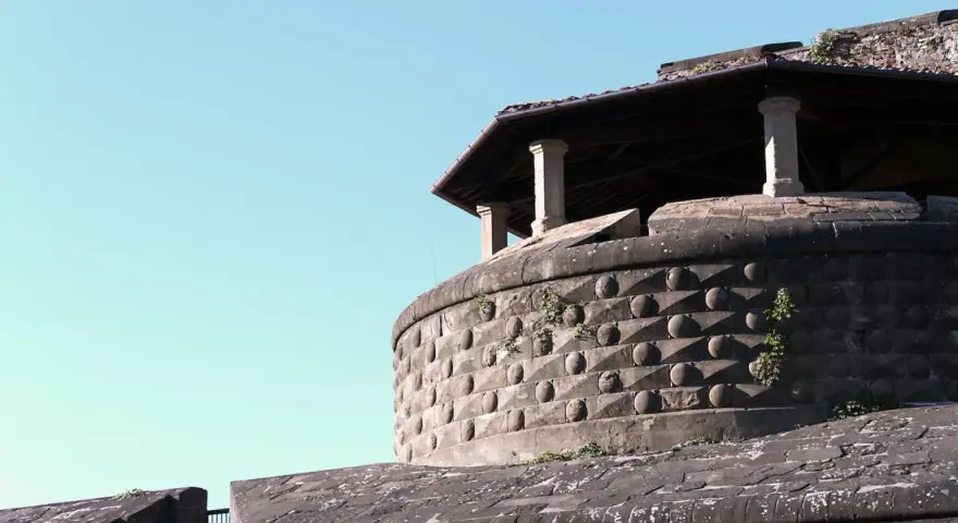La fortezza da basso, con la sua muratura bugnata e il tetto spiovente sorretto da colonne, si staglia contro il cielo azzurro.