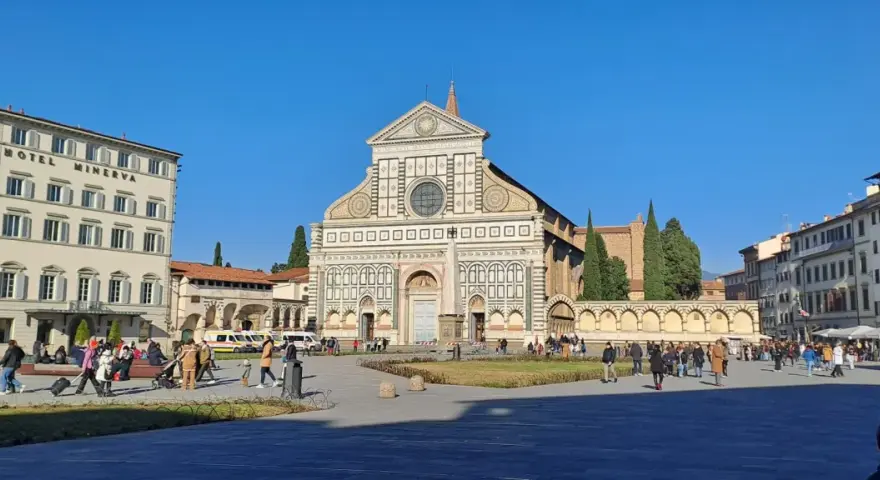 Piazza Santa Maria Novella a Firenze, con la facciata rinascimentale della basilique santa maria novella in primo piano e il Grand Hotel Minerva sulla sinistra.