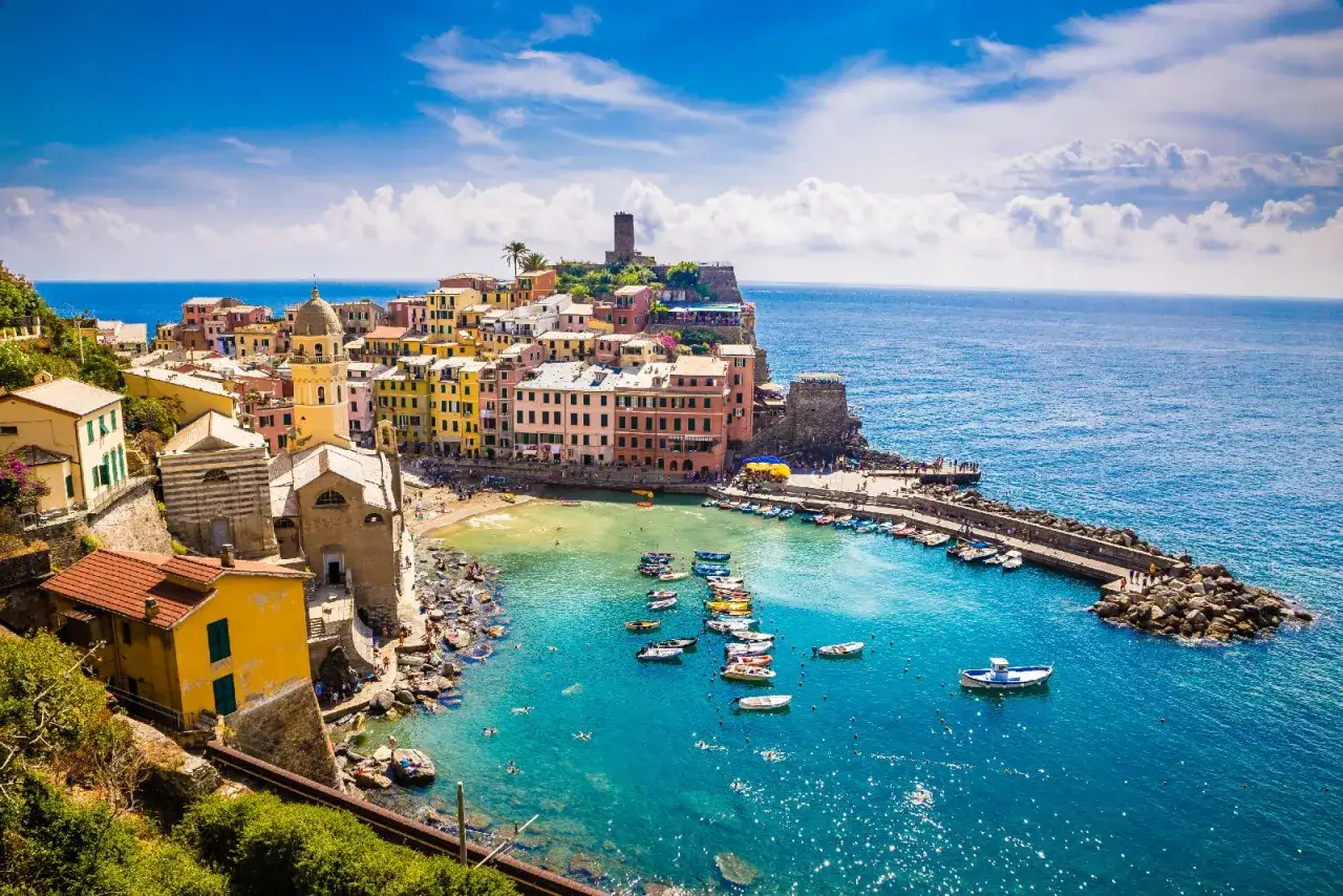 Vernazza, una delle perle delle Cinque Terre, con le sue case colorate a picco sul mare blu e le barche che ondeggiano nella baia.