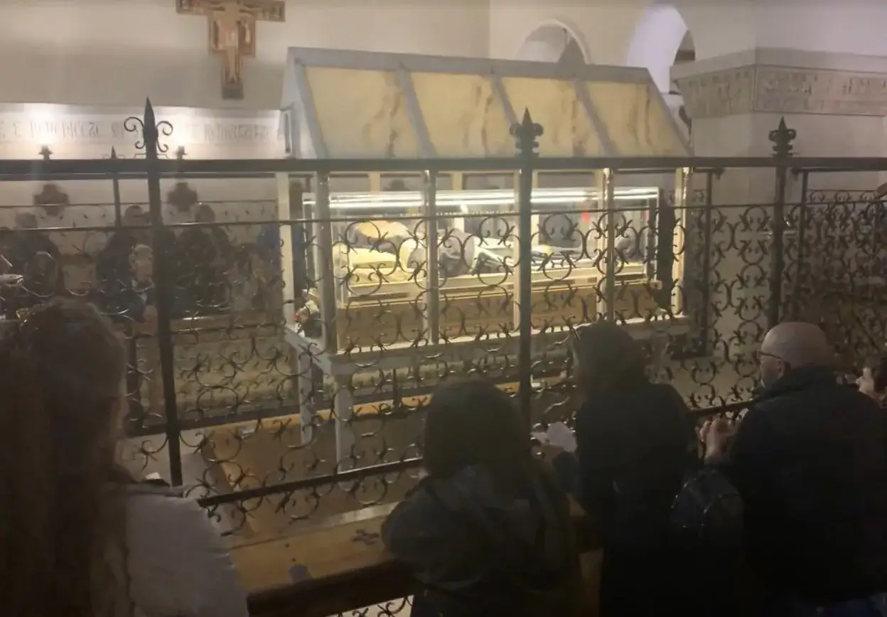 Folla in preghiera davanti alla teca di Padre Pio, dove si trova il suo corpo incorrotto.
