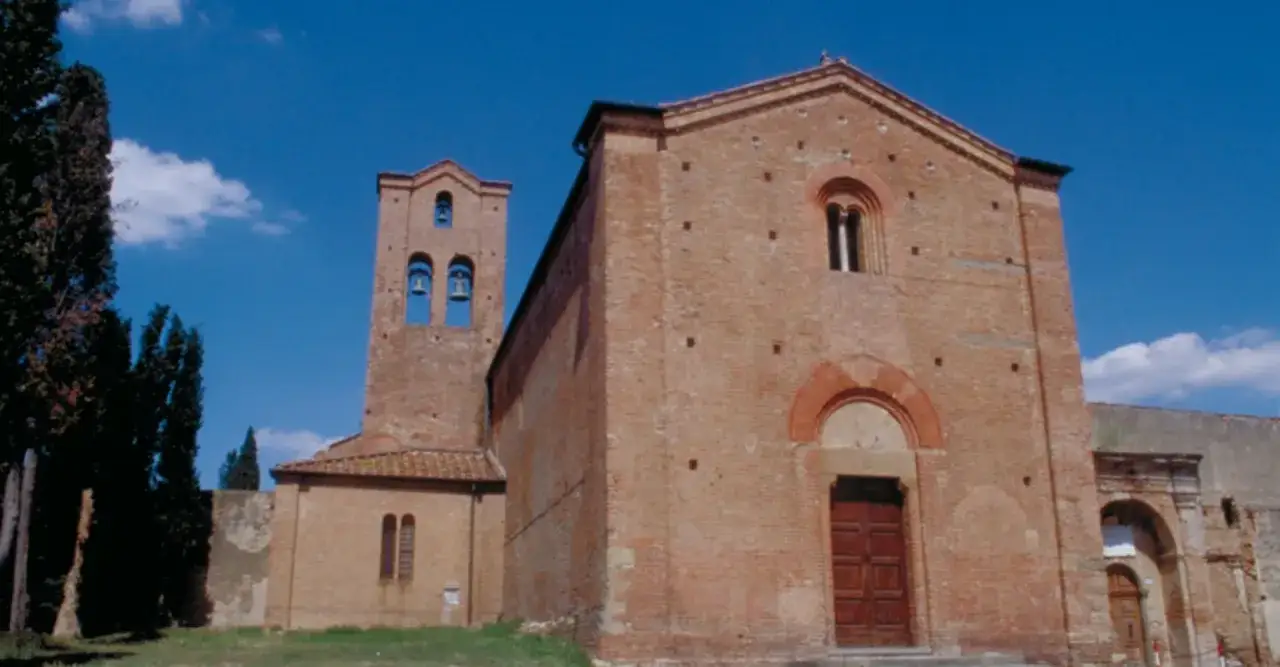 Chiesa romanica in mattoni a Castelfiorentino, cosa vedere: campanile con campane, facciata con rosone e portale.