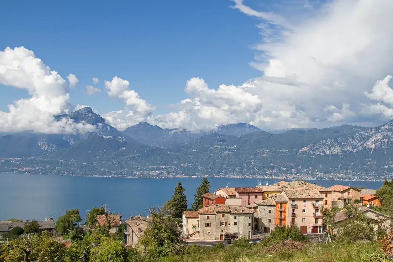 Case colorate a San Zeno di Montagna, con il lago e le montagne sullo sfondo.