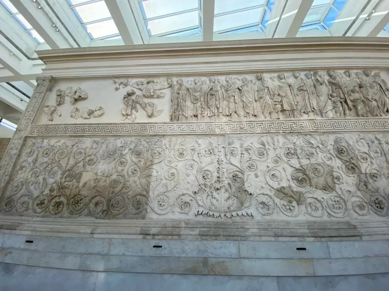 Rilievi dell'Ara Pacis: una processione di figure e decorazioni floreali intricate, testimonianza dell'arte romana.