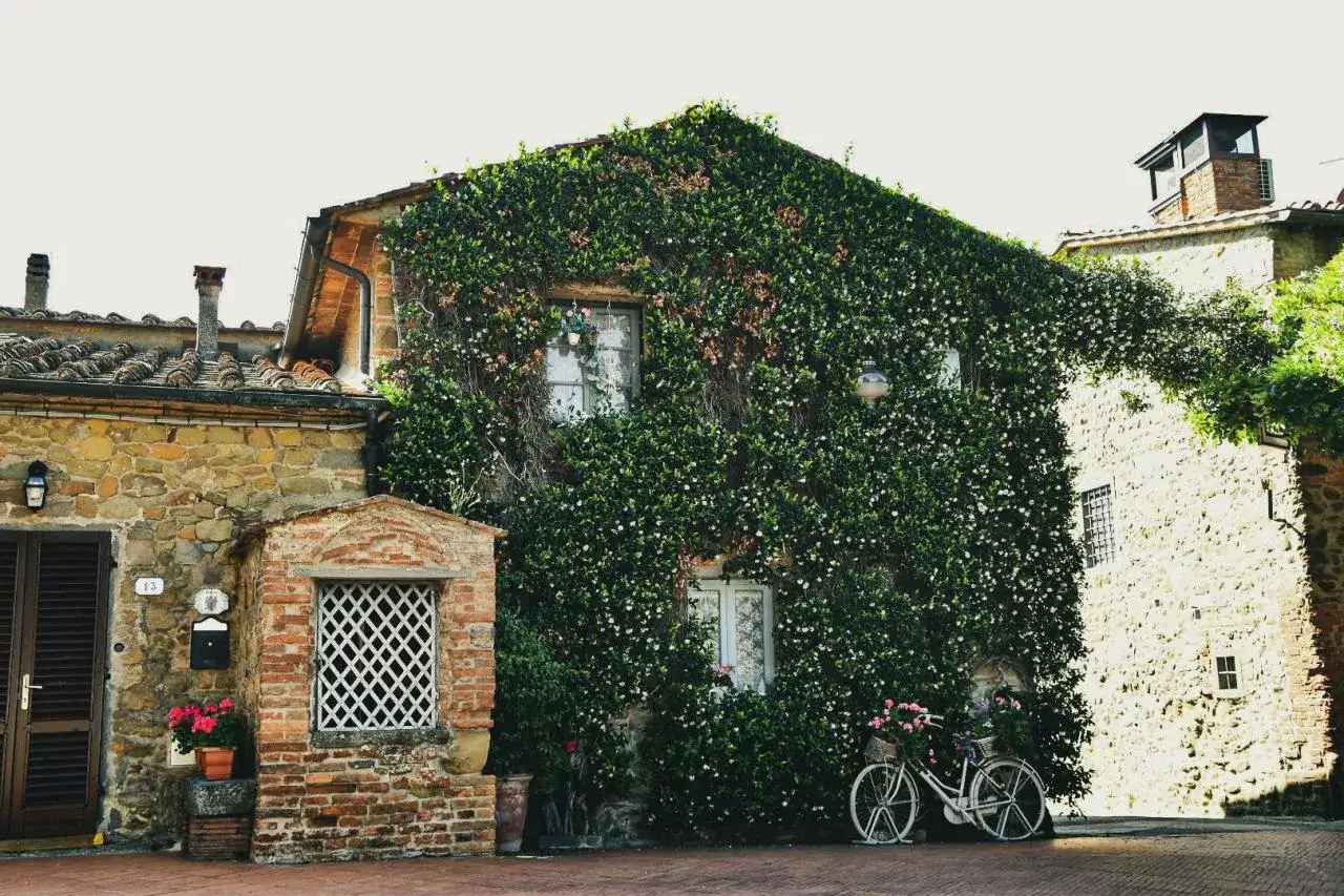 Un angolo incantevole di Vinci, con una casa ricoperta di fiori e una bicicletta vintage. Perfetto per scoprire cosa vedere a Vinci.