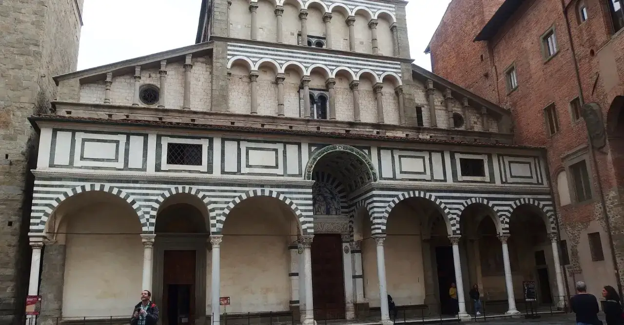 Il Duomo di Pistoia, con la sua facciata a fasce bianche e verdi, archi e colonne, si erge maestoso.