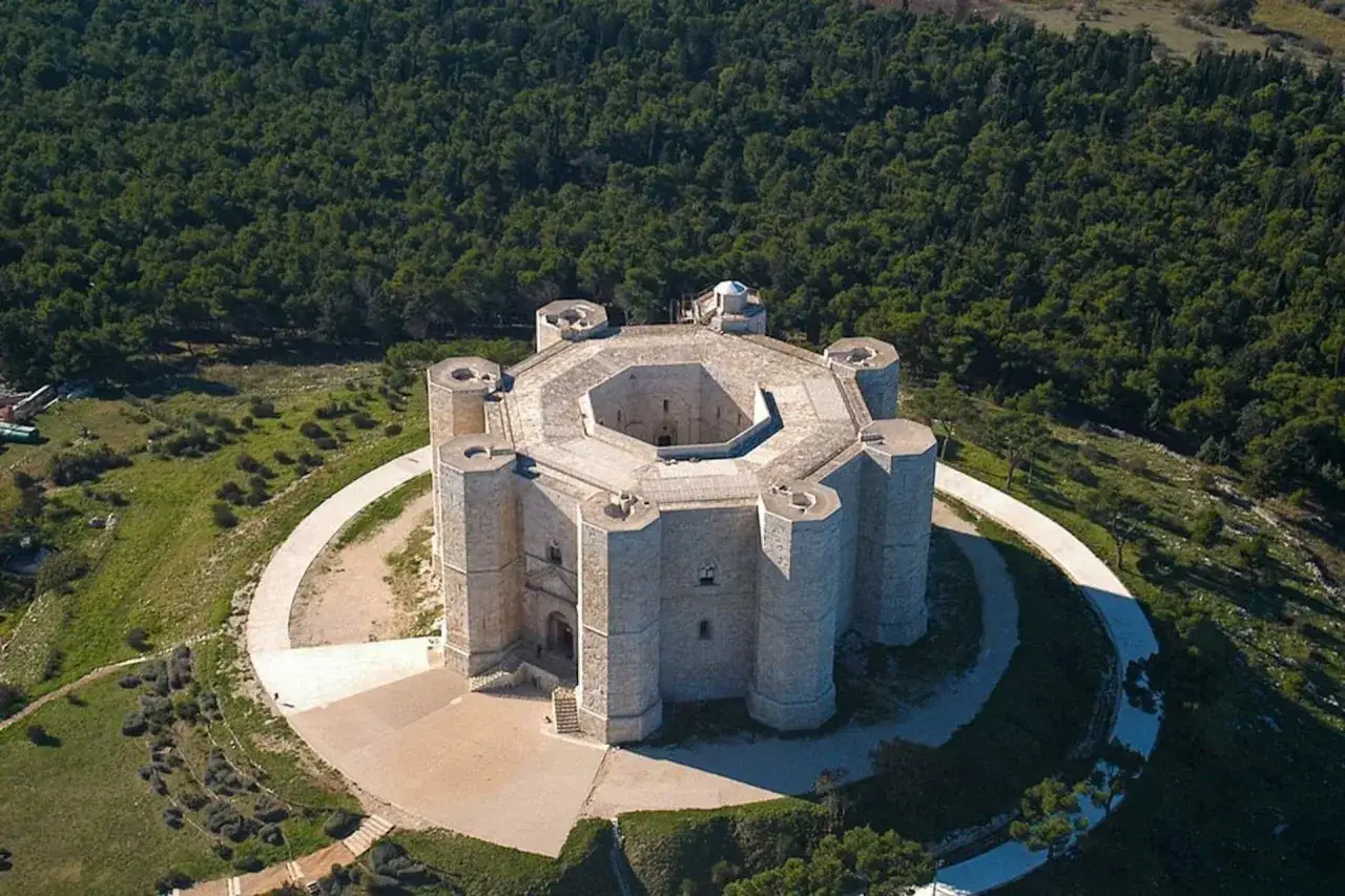 Castel del Monte, un'icona ottagonale in Puglia, si erge maestoso su una collina circondata da una foresta.