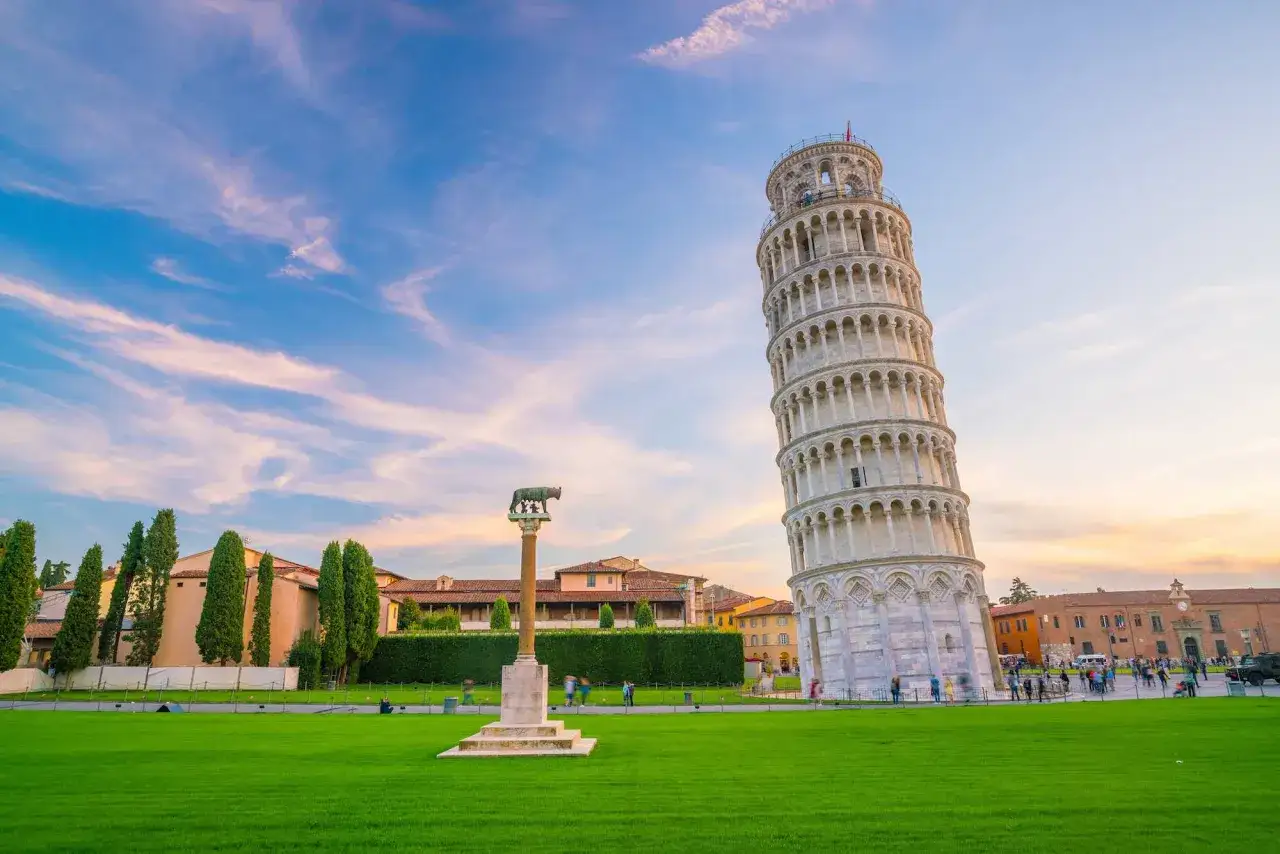 Il schiefe Turm von Pisa si ergege in tutta la sua gloria, inclinato ma maestoso, sotto un cielo al tramonto.