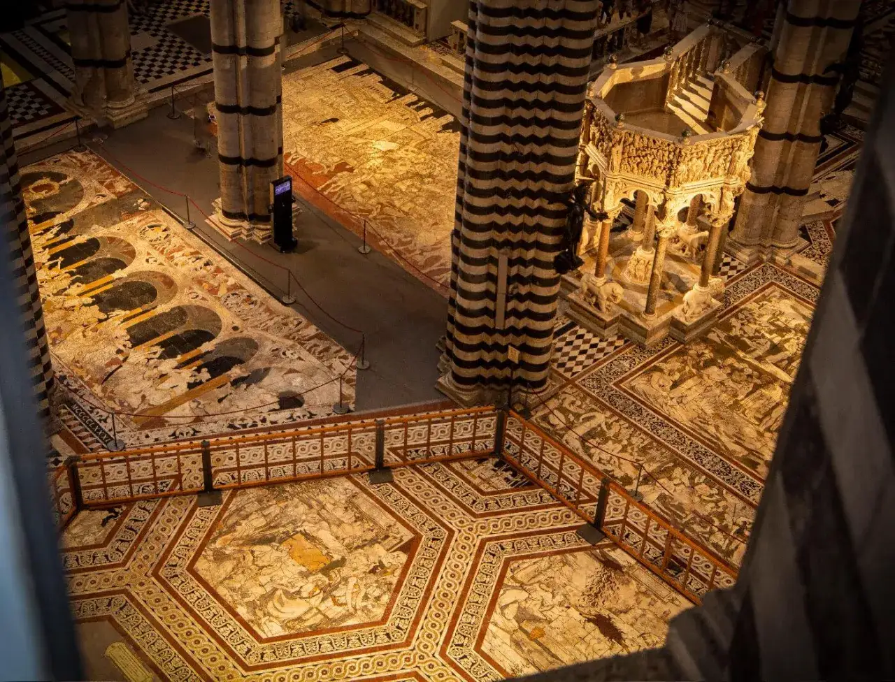 Interno del Duomo di Siena con pavimenti intarsiati e pulpito. L'ingresso gratuito al Duomo di Siena permette di ammirare queste meraviglie.