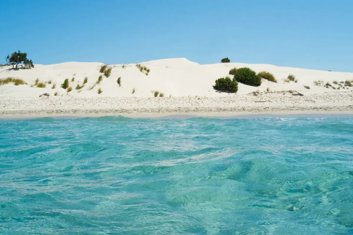 Acque cristalline e dune sabbiose caratterizzano la spiaggia di Porto Pino, un angolo di paradiso incontaminato.