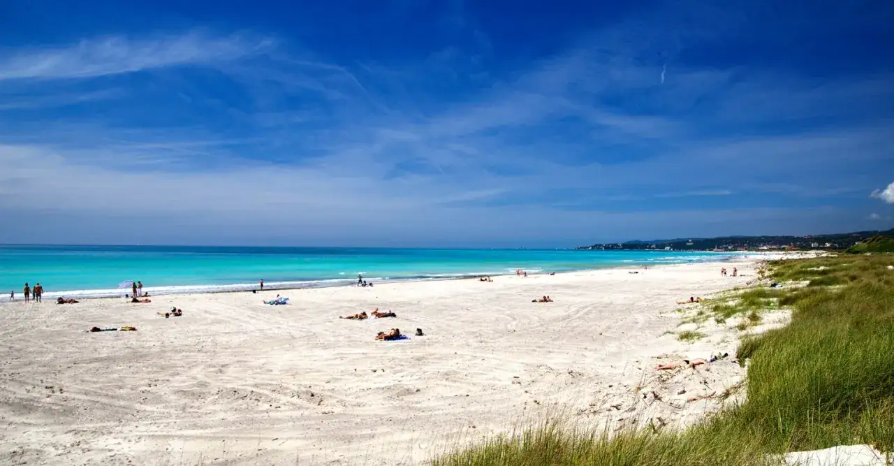 Vada white beach, con sabbia chiara e mare turchese, bagnanti prendono il sole sotto un cielo azzurro.