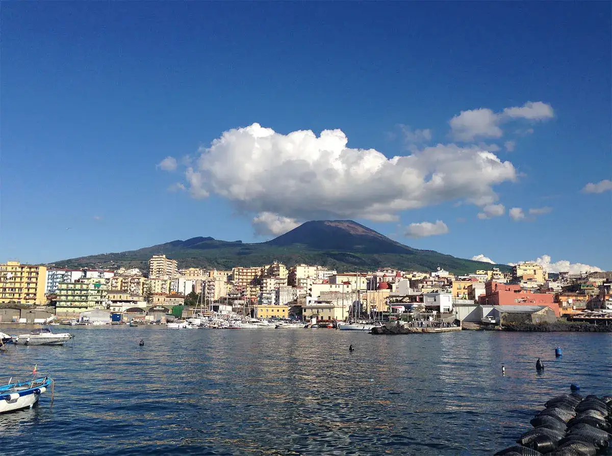 Vista del Vesuvio su Torre del Greco, con il porto e le barche in primo piano.